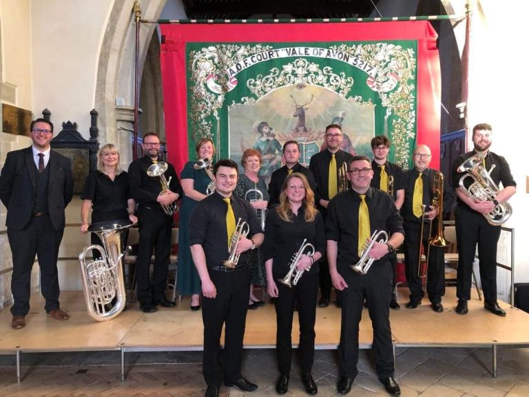 Foresters Brass Band standing on stage holding their musical instruments