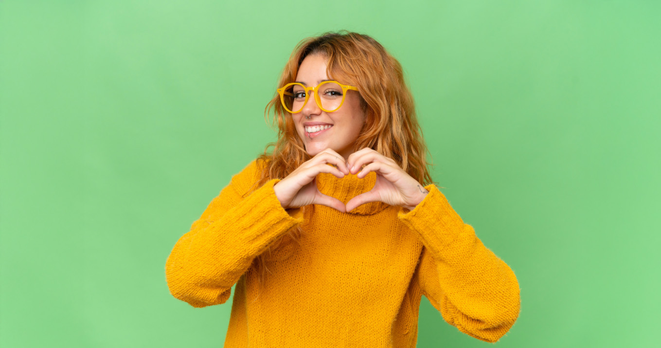 Happy woman making a heart symbol with her hands.